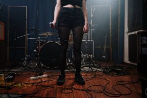 Woman in Black Denim Shorts Standing on Brown Wooden Floor